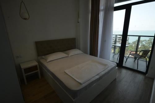 a bedroom with a bed with a view of a balcony at Thom Tower in Gonio