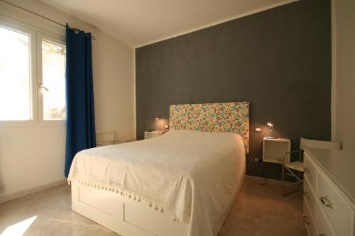 a bedroom with a white bed and a window at Grazioso appartamento non lontano dal mare in Trappeto