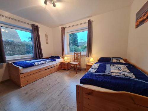 a bedroom with two beds and a window at Ferienwohnung Stadtfelder in Böhl