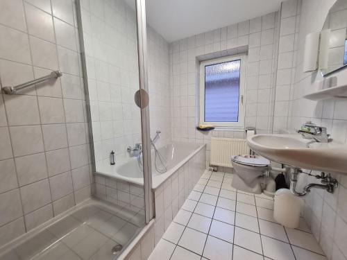 a bathroom with a shower and a toilet and a sink at Ferienwohnung Stadtfelder in Böhl