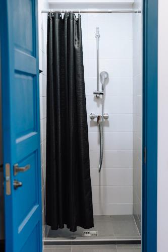 a shower with a black shower curtain in a bathroom at Brīvdienu māja Sniegi in Madona