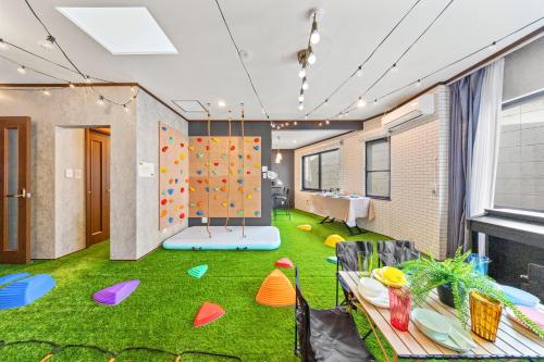 a play room with a climbing wall and green grass at 親子で遊べるボルダリングやボールプール付きの貸し切りアパート 国立駅徒歩4分 in Kunitachi