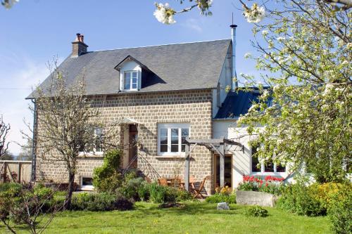 a brick house with a gray roof at La Nesliere Chambres d'Hôtes Bio in Saint-Symphorien-des-Monts
