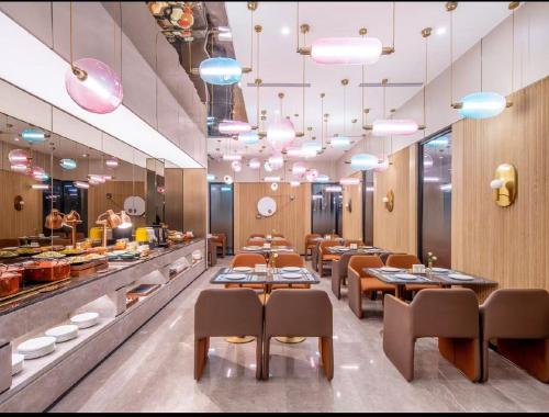 Un restaurante con mesas y sillas y un buffet. en Crystal Orange Hotel Beijing GuoMao Heshenghui Branch, en Beijing