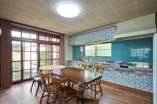 a kitchen with a table and chairs and blue tiles at Vacation Rental 八庵 HACHIAN in Hachinohe