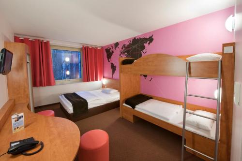 Kleines Zimmer mit 2 Etagenbetten und einem Tisch in der Unterkunft Hotel Hannover-Garbsen in Garbsen