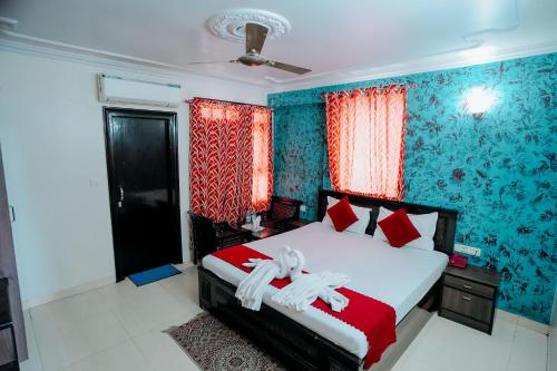 a bedroom with a bed with red and blue wallpaper at Hotel Jinendra Inn in Jaipur