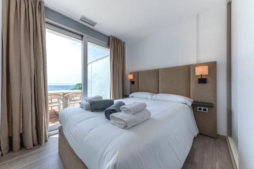a bedroom with a large bed with a large window at Montiboli Apartments by Buccara in Villajoyosa