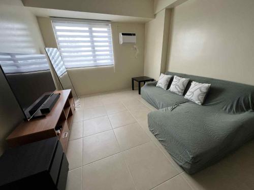 un salon avec un canapé et une table dans l'établissement Q Inn Serin East Tagaytay City, à Calo