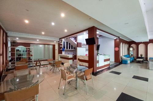 a dining room with a glass table and chairs at RedDoorz Hotel Baaraka near Living World in Pekanbaru