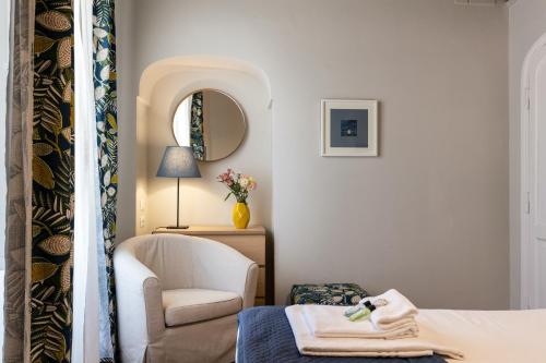 a room with a bed and a chair and a mirror at Rome as you feel - Grotta Pinta apartments in Rome