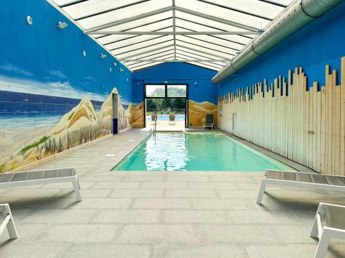 - une piscine dans un bâtiment doté d'un mur bleu dans l'établissement Maison mitoyenne de vacances - piscine commune et espaces verts - 4 personnes, à Saint-Hilaire-de-Talmont