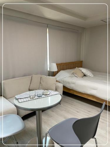 a living room with a couch and a table and a bed at Gangnam Cozy home 7 min to subway in Seoul