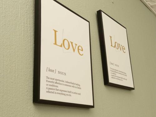 two framed pictures of love hanging on a wall at The Space Guesthouse in Vryheid