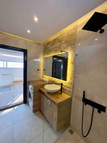 a bathroom with a sink and a mirror at Luxusvilla mit Panorama-Meerblick 20m Privatpool in Kusadası