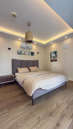 a bedroom with a large bed and a wooden floor at Luxusvilla mit Panorama-Meerblick 20m Privatpool in Kusadası