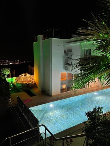 a building with a swimming pool at night at Luxusvilla mit Panorama-Meerblick 20m Privatpool in Kusadası