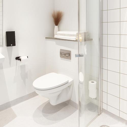 a bathroom with a toilet and a glass shower at CentralHotellet in Køge