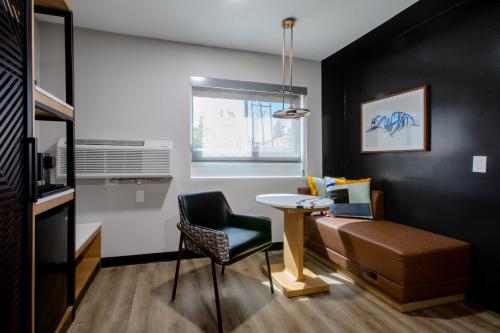 a living room with a table and a chair at voco Flagstaff by IHG in Flagstaff