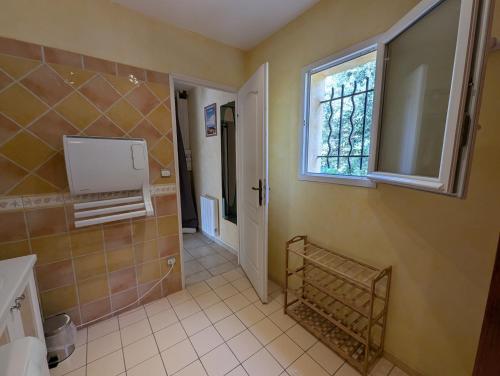 La salle de bains est pourvue d'un lavabo, d'une fenêtre et d'un miroir. dans l'établissement Villa parpailloun, jardin, piscine chauffée, à Flayosc