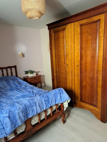 - une chambre avec une armoire en bois et un lit dans l'établissement AU COEUR de la TOURAINE, à Ballan-Miré