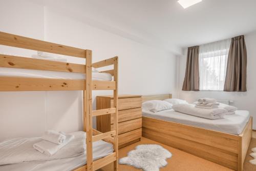 a bedroom with two bunk beds with white sheets at Aparthotel Klínovec Views in Loučná pod Klínovcem