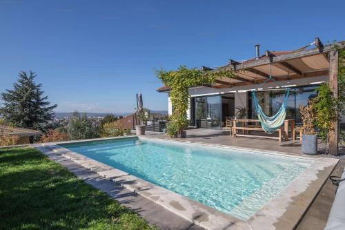 - une piscine dans l'arrière-cour d'une maison avec pergola dans l'établissement Annecy-le-vieux Villa Rainettes, à Annecy