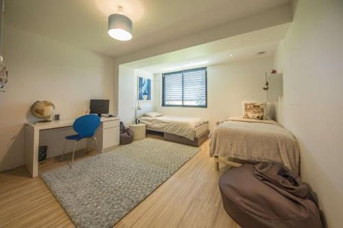 une chambre avec deux lits et un bureau et une fenêtre dans l'établissement Annecy-le-vieux Villa Rainettes, à Annecy