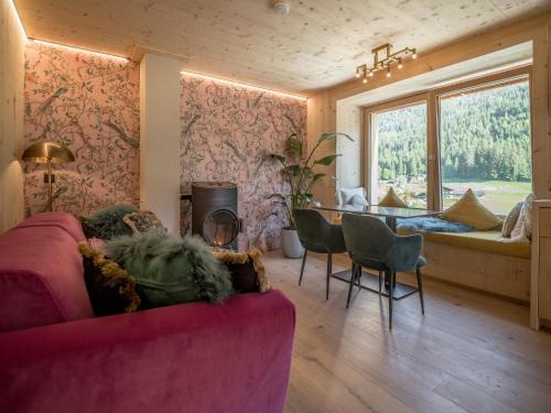 a living room with a pink couch and a table at Alpegg Chalets in Waidring