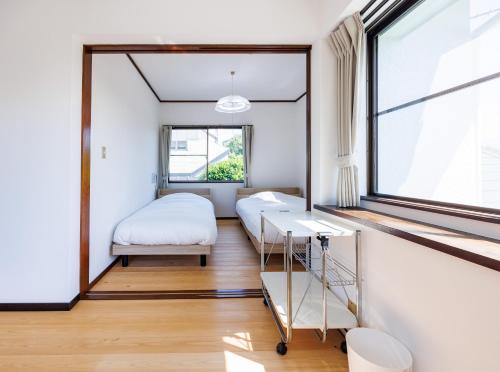 a bedroom with a bed and a window at Fuji別邸 in Fujinomiya