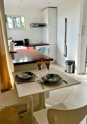 a kitchen with a table with two wine glasses on it at Suite by Chalet de Tahiti in Punaauia