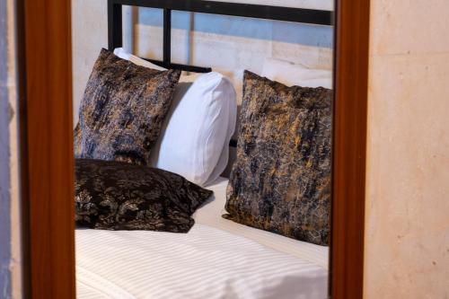 a reflection of a bed with pillows in a mirror at Kadim Hotel in Mardin
