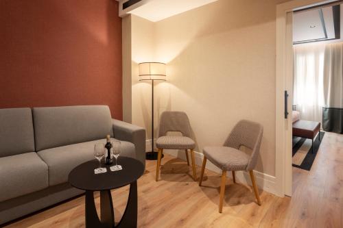 a living room with a couch and chairs and a table at Catalonia Plaza España Hotel & Spa in Madrid