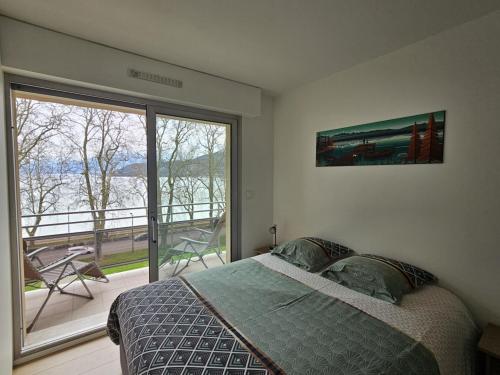une chambre avec un lit et une grande fenêtre dans l'établissement Annecy centre , Vue lac, ascenseur 4 pers, à Annecy
