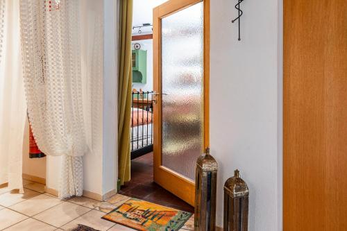 a hallway with a glass door and a mirror at Regina's Gästehaus in Weisenbach