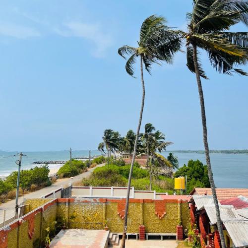a palm tree and a view of the beach at Kaustubha beach villa in Udupi