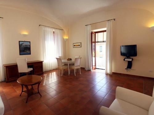 a living room with a table and chairs and a television at Palazzo Iaquinto in Santa Maria di Castellabate