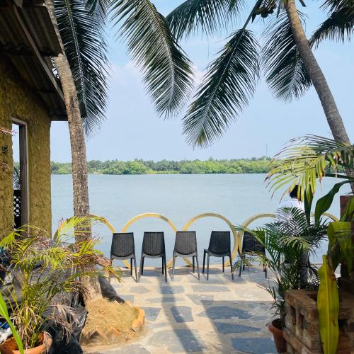 a patio with chairs and a view of the water at Kaustubha beach villa in Udupi