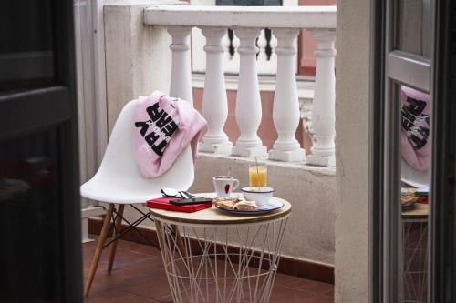 a table with a plate of food on a balcony at room00 Chueca Hostel in Madrid