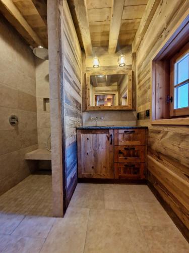 a bathroom with wooden walls and a sink and a shower at Les chryolles - Les mélèzes in Valmeinier