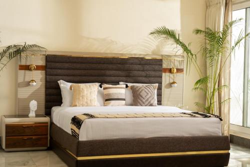 a bedroom with a large bed with a wooden headboard at Villa Raag in Agonda