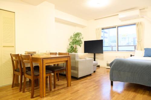a room with a table and a bed and a couch at Residence Hotel KABUTO in Sapporo