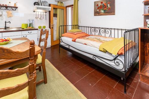 a kitchen with a bed and a table in a room at Regina's Gästehaus in Weisenbach