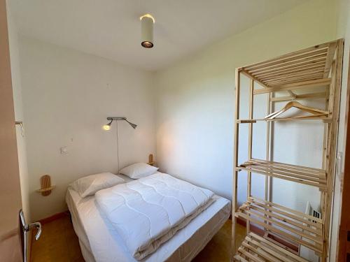 a bedroom with a white bed and a ladder at Village de Gîtes La Perdicie in Jumilhac-le-Grand