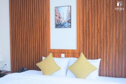 a bedroom with a bed with a wooden head board at The ONRA Hotel in Phnom Penh