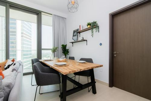 a dining room with a table and a couch at Elite Escape Holiday Home - 1 BHK Getaway with Dubai Mall Access - 1502 in Dubai