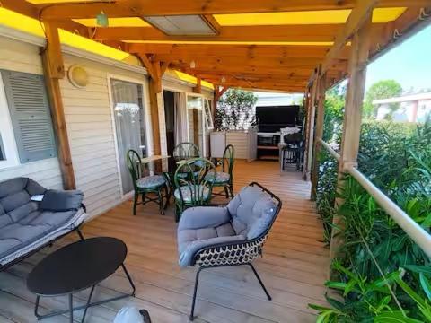 - une véranda avec des chaises et une table dans l'établissement Logis de l'étangs, à Fréjus