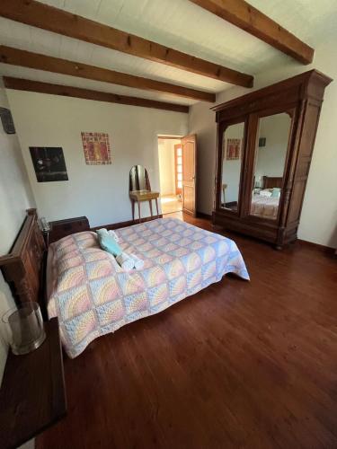 une chambre avec un lit et un grand miroir dans l'établissement Maison centre ville Saint Florent, à Saint-Florent