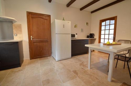 une cuisine avec un réfrigérateur blanc et une table dans l'établissement Maison centre ville Saint Florent, à Saint-Florent