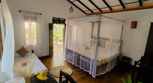 una camera da letto con un letto con zanzariera di Ginger Harmony Guesthouse and Cafe a Tangalle